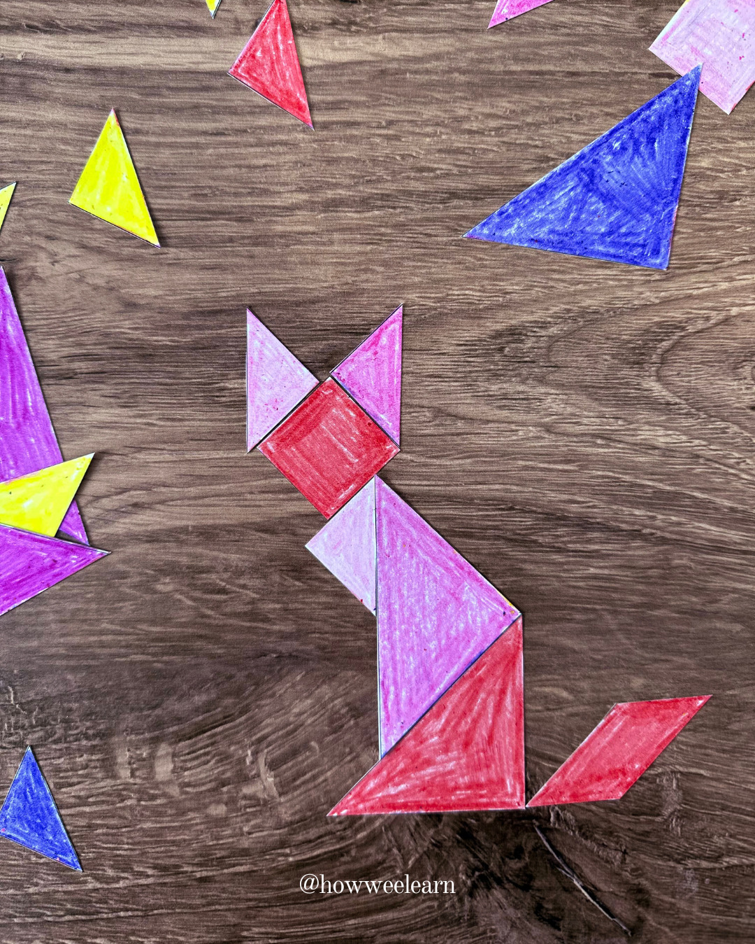 DIY tangram pieces in the shape of a cat coloured with crayon