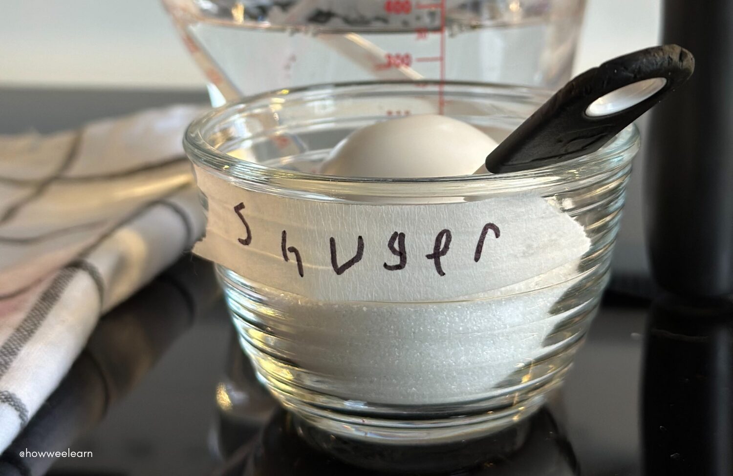 Small bowl of sugar with a label that says "shuger"