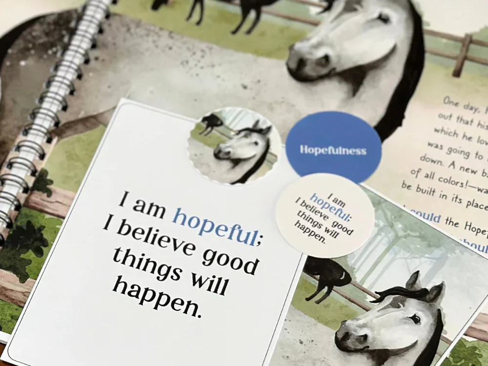 Picture of a workbook with a card on top that says, "I am hopeful; I believe good things will happen."